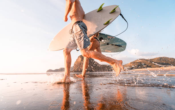 avventura di surf. - men beach running shirtless foto e immagini stock
