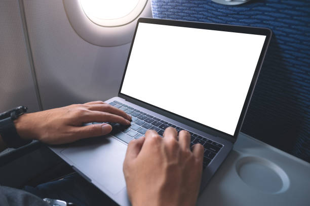 istock Mockup image of a man using and typing at laptop computer with blank white desktop screen while sitting in the cabin 1144765961