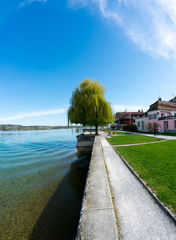 Steckborn, TG / Switzerland - 22 April 2019: tourists walk along the idyllic lakeshore in Steckborn on Lake Constance