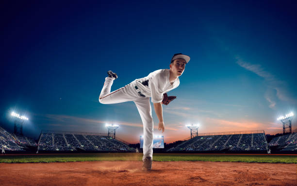 BASEBALL Baseball player at professional baseball stadium in evening during a game. baseball pitcher stock pictures, royalty-free photos & images