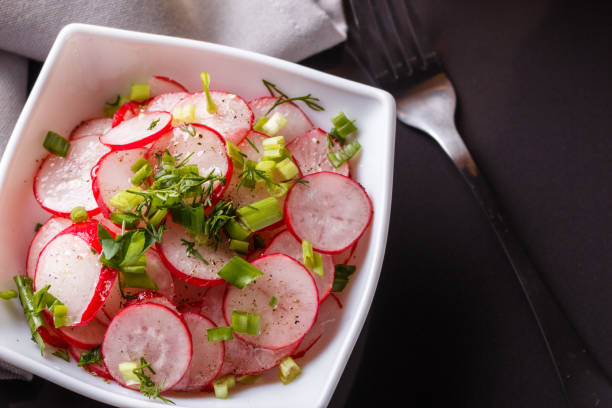 istock Radish salad in a white bowl on a dark background 1144772381