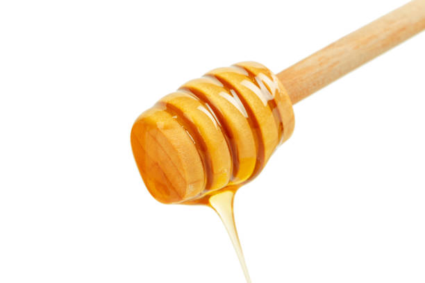 istock honey with wooden drizzler isolated on white background 1144776633