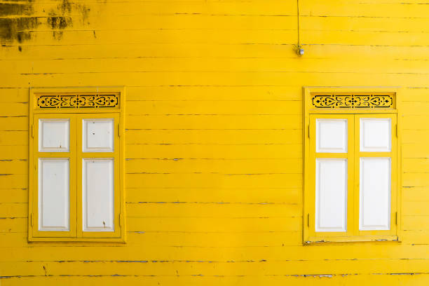 istock yellow peeling painted on wooden wall with white window, textures background, cracked paint 1144778175