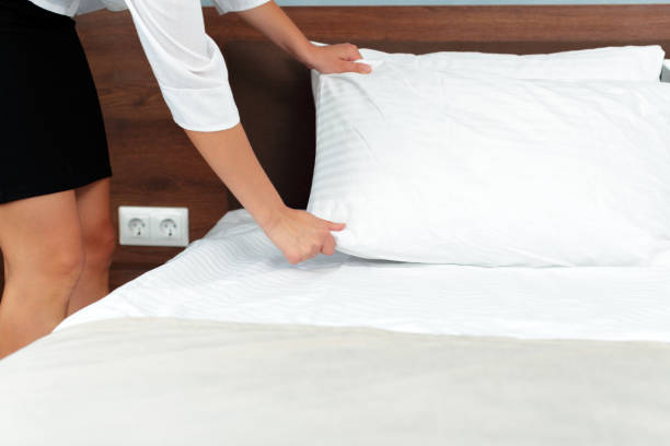 istock Young maid making bed in hotel room 1144779959