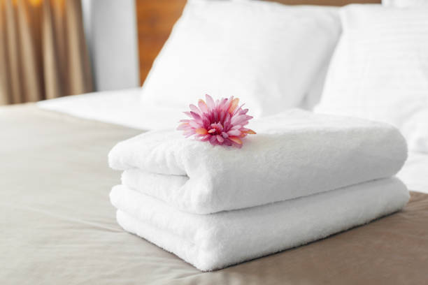 towels and flower on bed in hotel room towels and flower on bed in hotel room towel stock pictures, royalty-free photos & images