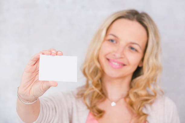 istock beautiful woman is holding white card for copy space 1144781028