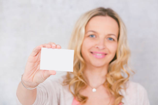 istock beautiful woman is holding white card for copy space 1144781045