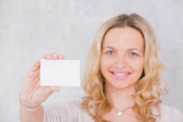 istock beautiful woman is holding white card for copy space 1144781129