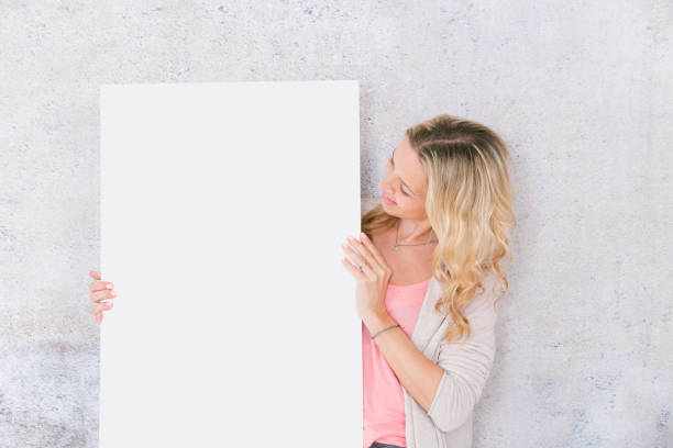 istock beautiful woman is holding white card for copy space 1144781145