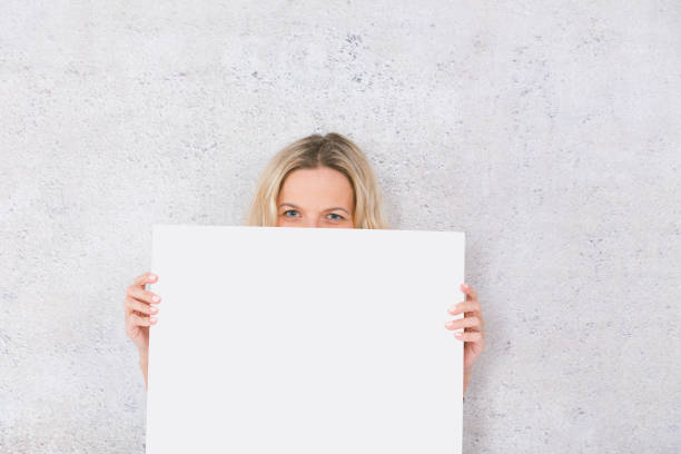 istock beautiful woman is holding white card for copy space 1144781201