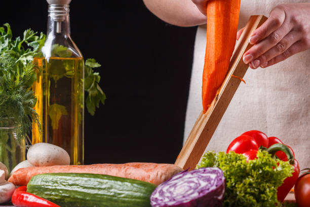 istock young woman in a gray apron cuts carrots 1144781249