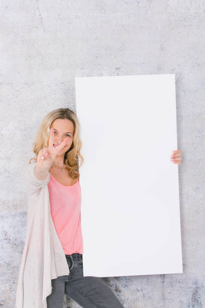 istock beautiful woman is holding white card for copy space 1144781293