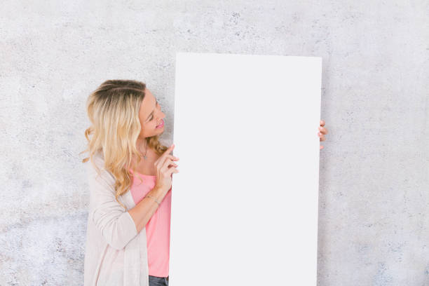 istock beautiful woman is holding white card for copy space 1144781303