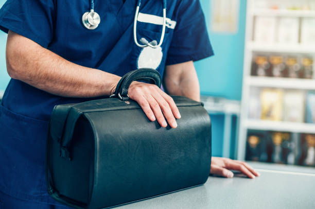 Doctor's Bag Close up of veterinarian with stethoscope, holding leather doctor's bag in vet clinic doctors bag stock pictures, royalty-free photos & images