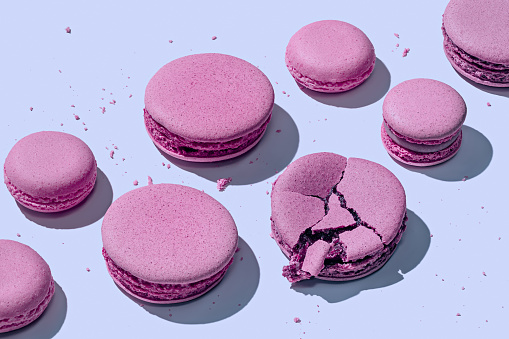 Delicious lavender macarons on pastel blue background with shadows