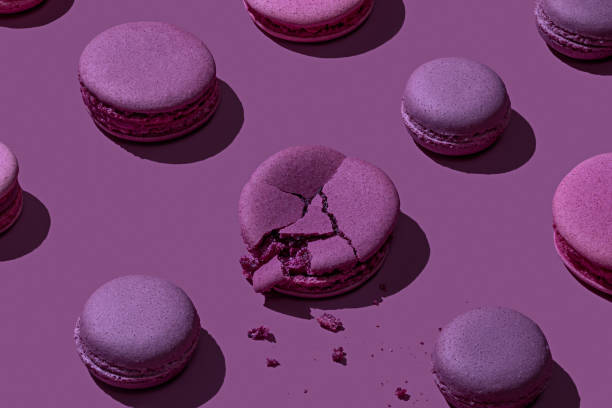Purple macarons on purple background Monochrome concept with fresh purple macarons on purple background with shadows crumb photos stock pictures, royalty-free photos & images