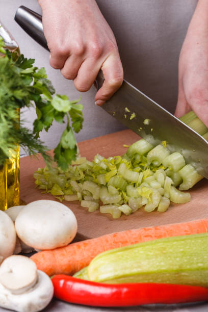 istock young woman in a gray apron cuts a celery 1144786410