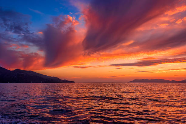 золотой закат на море после шторма с темными облаками - lyrical стоковые фото и изображения