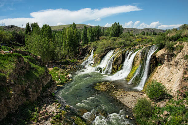 istock Waterfalls in a green setting under blue skies 1144788685