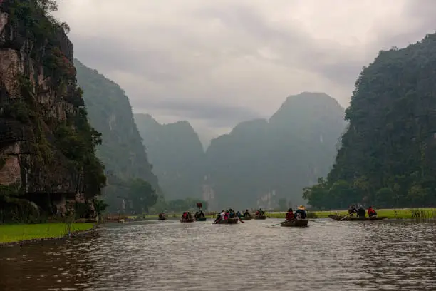 Photo of Row boats on a river under cast sky in Vietnam