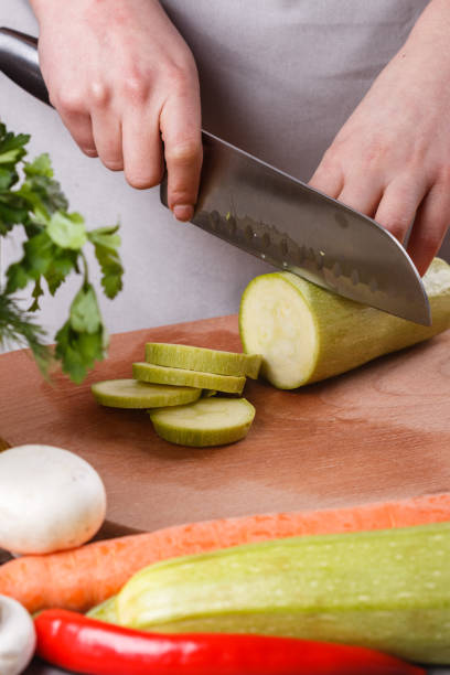 istock young woman in a gray apron cuts a zucchini 1144789106