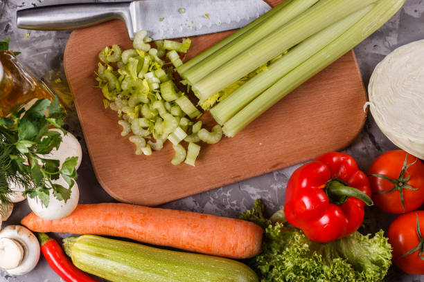 istock young woman in a gray apron cuts a celery 1144789134