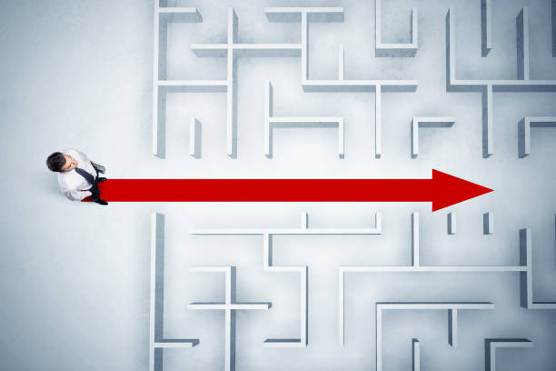 istock Business man looking at maze with red arrow 1144789215