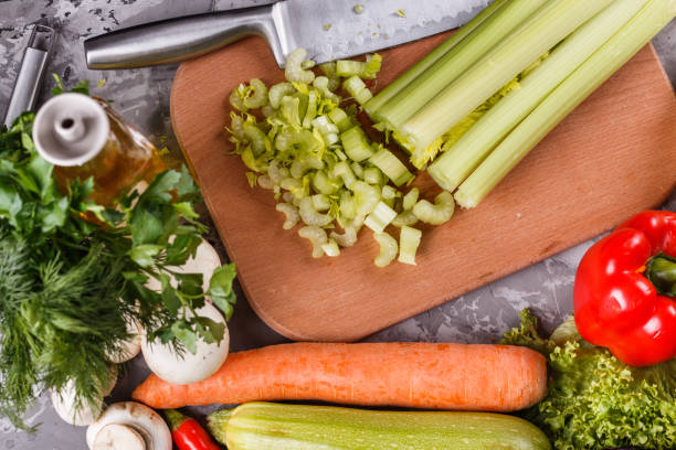 istock young woman in a gray apron cuts a celery 1144789256