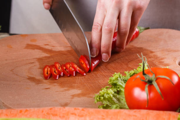 istock young woman slicing peppers in a gray apron 1144792874
