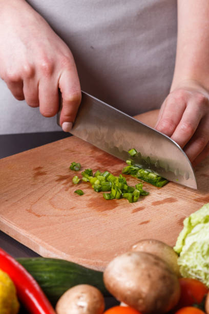istock young woman slicing herbs in a gray apron 1144792886
