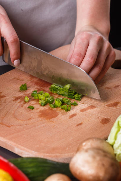 istock young woman slicing herbs in a gray apron 1144792910