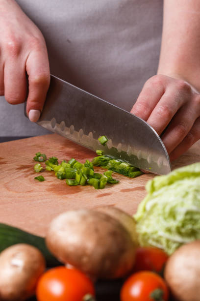 istock young woman slicing herbs in a gray apron 1144792934