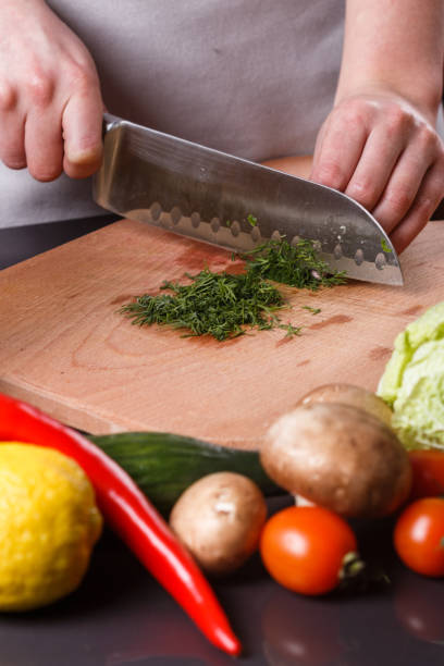 istock young woman slicing herbs in a gray apron 1144792976
