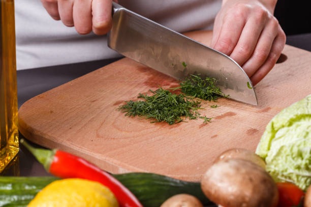 istock young woman slicing herbs in a gray apron 1144792995