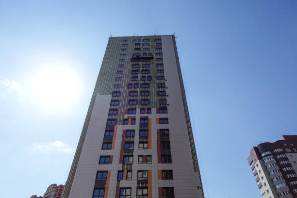 istock High-rise building under construction against the blue sky. The building is trimmed with external decorative panels. Russia 1144794608