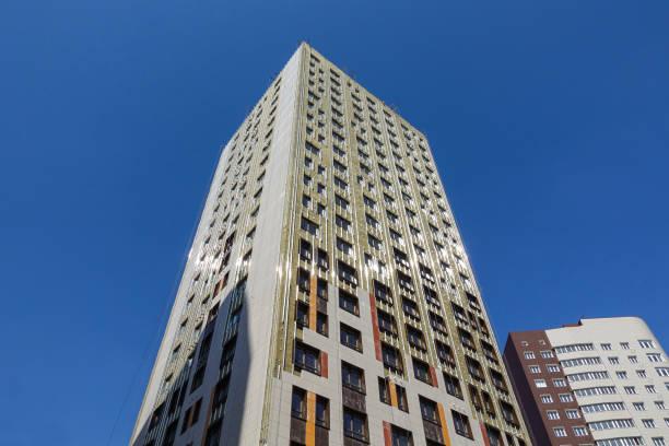 istock High-rise building under construction against the blue sky. The building is trimmed with external decorative panels. Russia 1144794616
