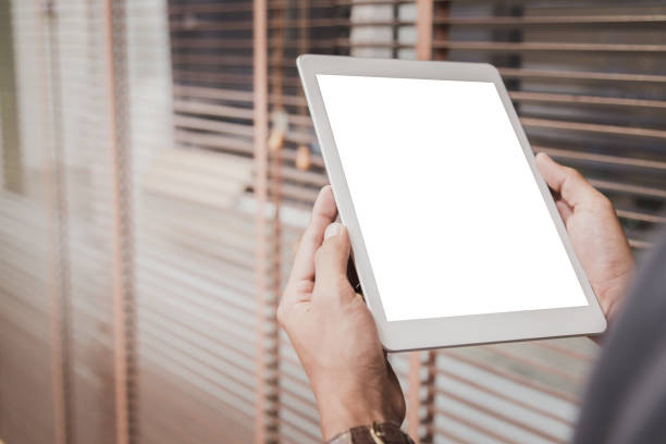 Mockup tablet on businessman hands empty display on home table with blur background
