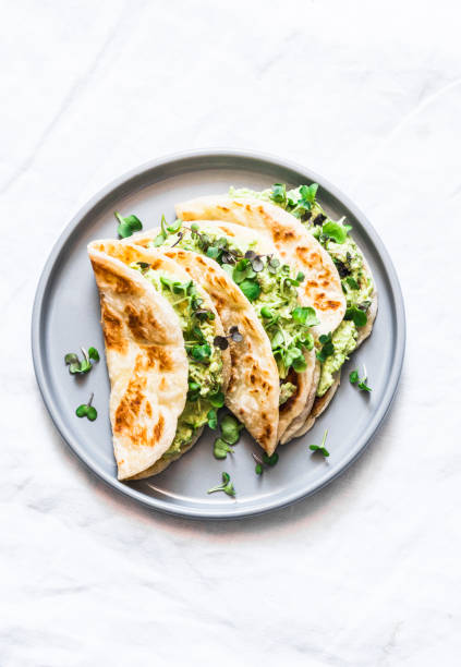 istock Avocado eggs greens salad paratha flatbread quesadilla on a light background, top view 1144796507