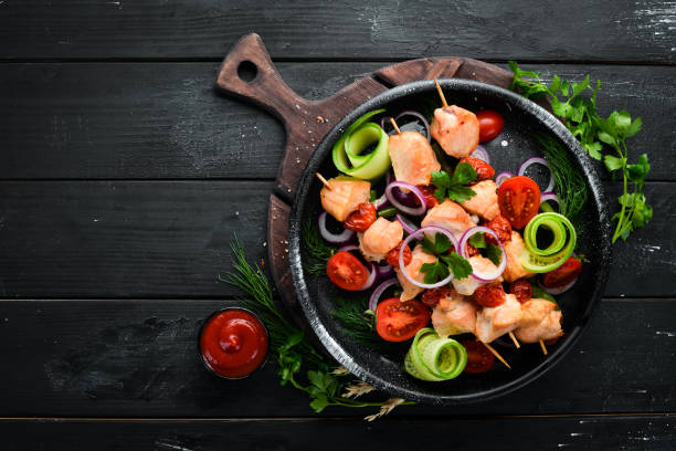 istock Chicken kebab with vegetables. Kebab in a black plate. Top view. Free copy space. 1144796594
