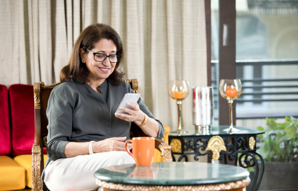 istock Senior woman using mobile phone at home 1144796816