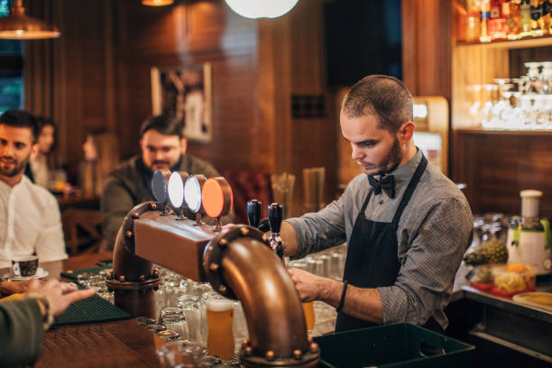 istock Bartender pouring beer for customers in bar 1144796954