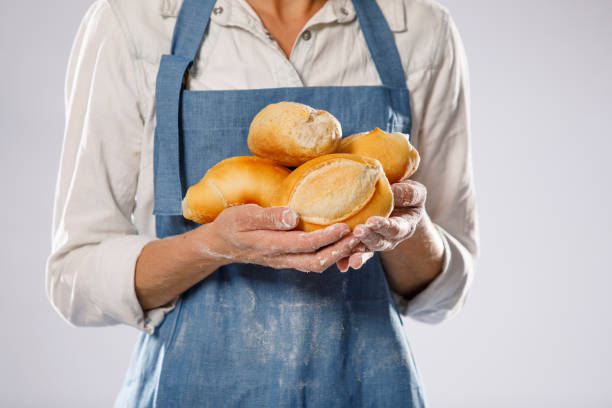 Baker with apron Holding bread stock photo