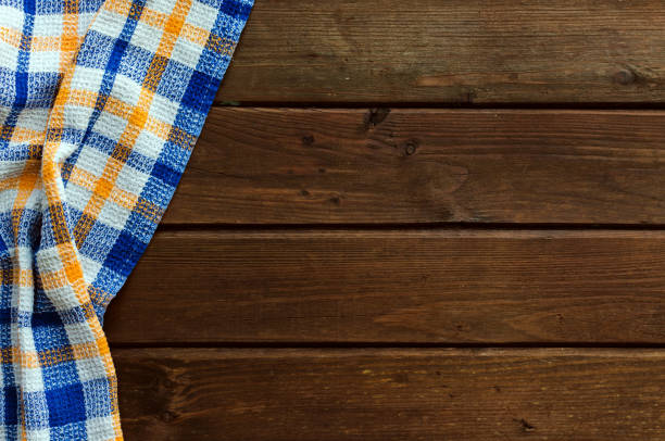 istock Blue checkered picnic cloth on brown wooden table. 1144800087
