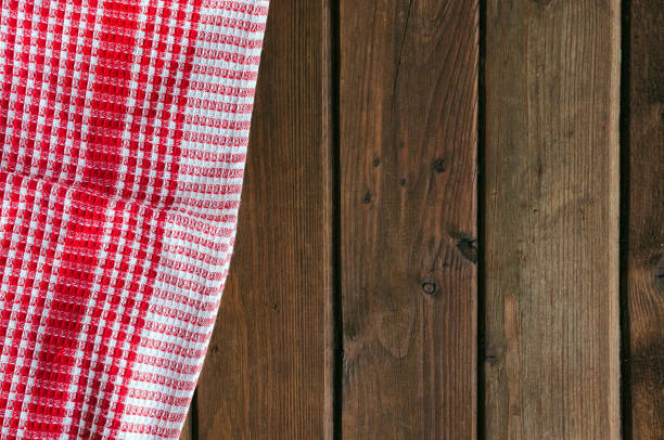istock Red checkered picnic cloth on brown wooden table. 1144800098