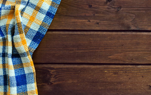 istock Blue checkered picnic cloth on brown wooden table. 1144800103