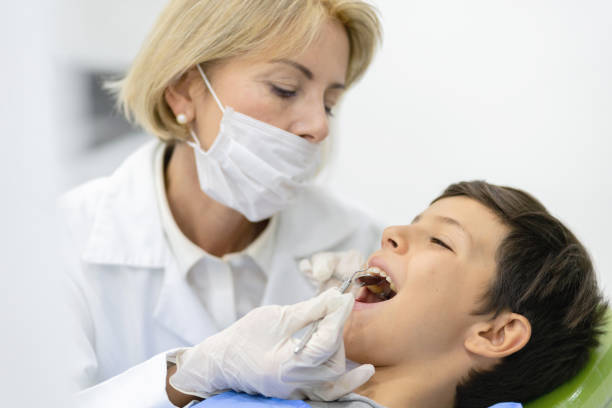 istock Dentist checking the teeth of a boy 1144800325