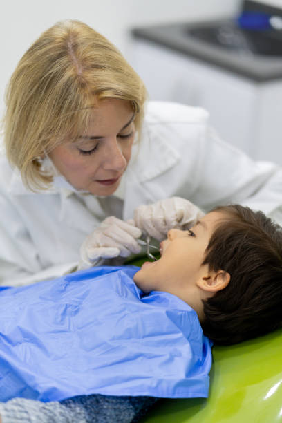 istock Portrait of a dentist looking at a boy's teeth 1144800345