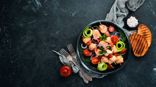 istock Chicken kebab with vegetables. Kebab in a black plate. Top view. Free copy space. 1144803758