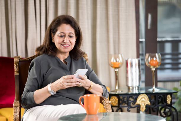 istock Senior woman using mobile phone at home 1144805172
