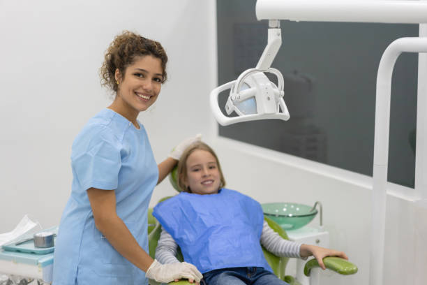 istock Happy dentist with a young female patient 1144805833